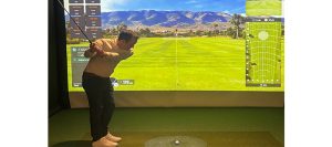 Man plays golf on simulator at 24Swing Indoor Golf